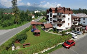 a house with a red car parked next to a street at APLEND Vila Beatrice in Vysoke Tatry - Tatranska Lomnica.