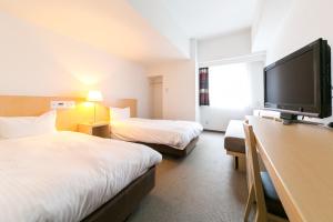 a hotel room with two beds and a flat screen tv at Pearl Hotel Kayabacho in Tokyo +27 photos