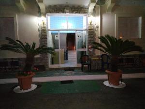 a lobby with two palm trees in front of a building at 85 m² Apartments New Panorama (under new management) in Paralio Astros