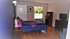 a bedroom with a bed and a dresser and a window at Classic Motor Lodge Providence - West Greenwich in West Greenwich