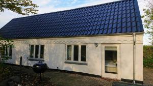 a small white house with a blue roof at B&B Hesselbjerg in Hesselbjerg