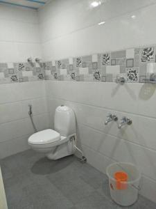 a bathroom with a toilet and a trash can at Ashoka Residency Chottanikkara in Chottanikara