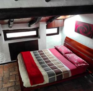 um quarto com uma cama com um cobertor vermelho e castanho em Le Lanterne em Albavilla