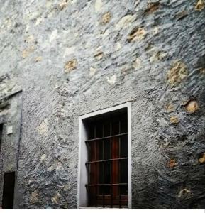 uma janela no lado de um edifício de pedra em Le Lanterne em Albavilla