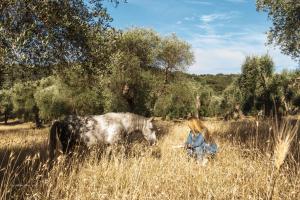 a little girl in a field with a horse at Casa Masseria Le Ville in Peschici