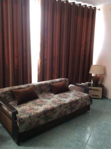 a bed sitting in a room with curtains at Отель Идиллия in Dzhubga