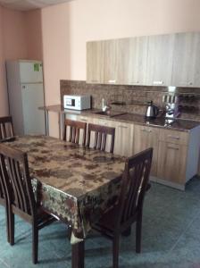 - une table et des chaises dans une cuisine avec une table et un comptoir dans l'établissement Отель Идиллия, à Dzhubga