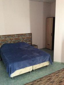 1 dormitorio con 1 cama con manta azul en Отель Идиллия, en Dzhubga