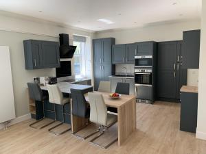 a kitchen with blue cabinets and a table and chairs at Cliffside in Lossiemouth