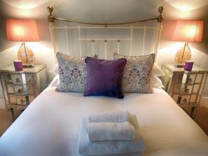 a bedroom with a bed with a chair and two lamps at Century House in Moreton in Marsh