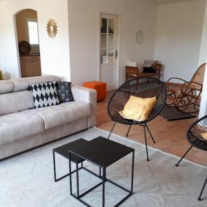 a living room with a couch and chairs and a table at Maison de vacances près de Marciac in Troncens