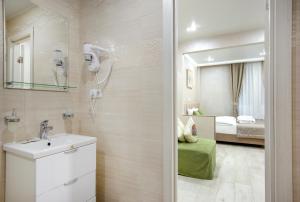 un bagno con lavandino e una camera con un letto di Grand Mark by ACADEMIA a San Pietroburgo