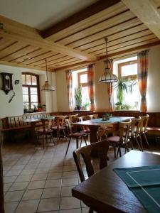 Friesau的住宿－Gasthaus Goldner Löwe，餐厅设有桌椅和窗户。