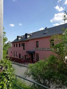 a pink building with a fence in front of it at Gasthaus Goldner Löwe in Friesau