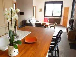 a living room with a wooden table with a vase of flowers at La Mésange in Millau