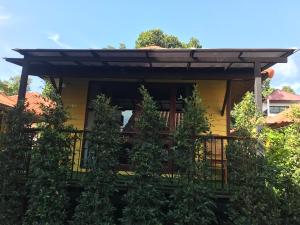 a house with a balcony with trees at Ricci House Resort in Ko Lipe