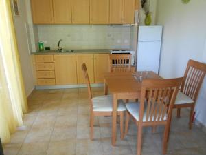eine Küche mit einem Tisch und Stühlen sowie einem Kühlschrank in der Unterkunft Villa Swan in Lefkada Town
