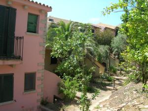 an alley between two buildings with trees at Villaggio Sa Ventana in Badesi