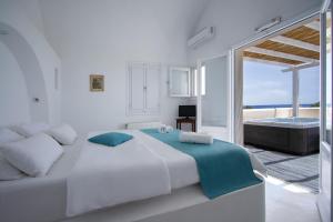 a white bedroom with a large bed and a tub at Sea Sound White Katikies in Perivolos