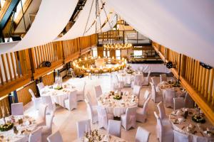 a banquet hall with white tables and white chairs at Heide Hotel Reinstorf in Reinstorf
