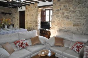 ein Wohnzimmer mit Sofa und Tisch in der Unterkunft Cortijo Rural Las Nogueras in Cortijada Los Chorreros
