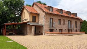 een groot bakstenen gebouw met een rood dak bij Gyulai-fürdő-apartman II. in Gyula