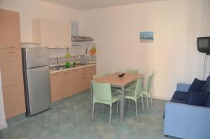 eine Küche mit einem Tisch und Stühlen sowie einem Kühlschrank in der Unterkunft Rada Delle Tortore in Marzamemi