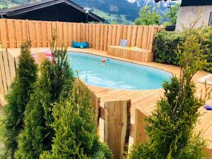 a small swimming pool in a backyard with a wooden fence at Apartments Chalet Sonnentanz in Piesendorf