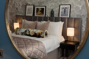 a mirror reflecting a bedroom with a bed with pillows at Gonville Hotel in Cambridge