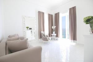 a white living room with a couch and a mirror at Hotel Marincanto in Positano