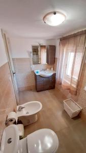 a bathroom with a sink and a toilet and a sink at La Petite Maison in Aci Castello +59 photos