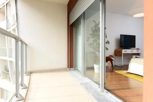 a room with sliding glass doors and a tv at New loft with swimming pool at Parque das Nações! in Lisbon