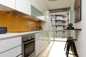 a kitchen with white counters and orange tiles at New loft with swimming pool at Parque das Nações! in Lisbon
