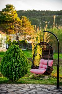 a pink chair in a swing in a garden at Villa Swan in Lefkada Town