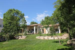 une maison avec une cour et des arbres devant elle dans l'établissement Le Fournil en Provence, à Caseneuve
