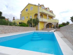 a villa with a swimming pool in front of a house at Apartments Ankica in Šibenik