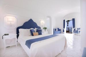 a white and blue bedroom with a large bed at Hotel Marincanto in Positano