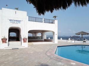 マンサニージョにあるPuerto Las Hadas Apartamentosの海辺のスイミングプール付きの建物