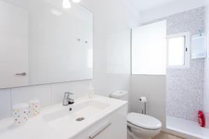a white bathroom with a sink and a toilet at The wave house El Médano in El Médano +26 photos