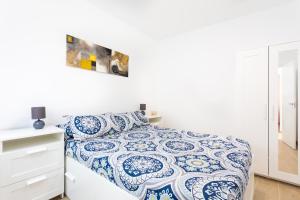 Dormitorio blanco con cama azul y blanca en The wave house El Médano, en El Médano