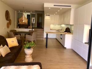 a living room and kitchen with a couch and a table at Cabopino in Marbella