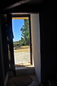 an open door with a view of a field at Moinho da Senta in Rio Maior