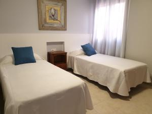 a room with two beds and a window at Sunny & New Apartamento in Caleta de Fuste in Caleta De Fuste