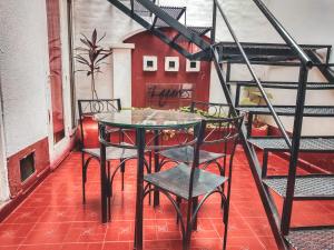 a glass table and chairs on a balcony at Hostel Lagares in Mendoza