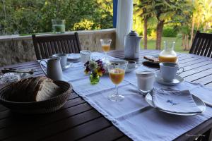 a table with a blue table cloth and glasses of orange juice at Chambre d'Hôtes au Sargaillon in Pouillon