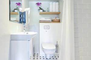 een badkamer met een wit toilet en een wastafel bij Rotermann City Apartments in Tallinn +31 foto's