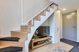 een woonkamer met een trap en een tv bij Rotermann City Apartments in Tallinn