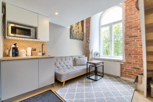 een woonkamer met een bank en een raam bij Rotermann City Apartments in Tallinn
