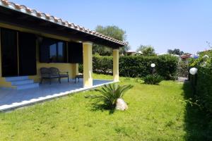 dom z patio i trawnikiem w obiekcie Villa Azzurra nel centro di Costa Rei w mieście Costa Rei