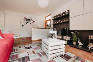 a living room with a red couch and a bike on the wall at ROSE GARDEN in Tezze